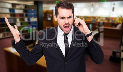 Composite image of angry businessman gesturing on the phone