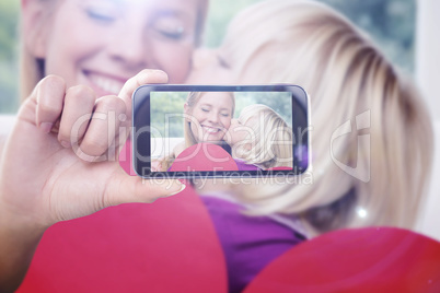 Composite image of hand holding smartphone showing