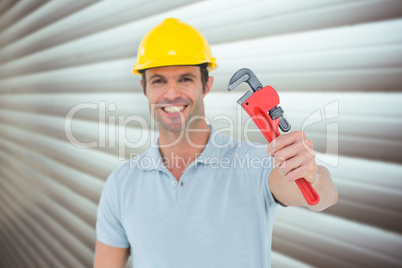 Composite image of happy carpenter holding monkey wrench