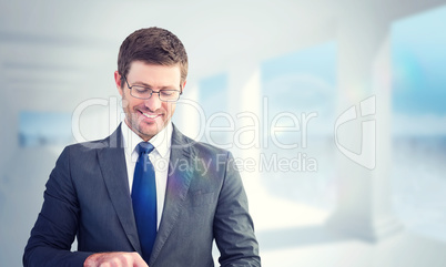 Composite image of businessman using his tablet pc