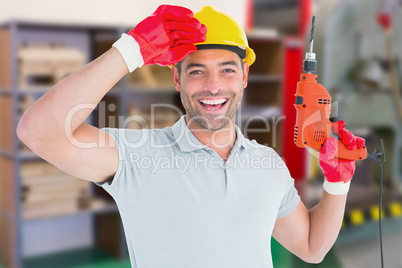 Composite image of smiling manual worker holding drill machine