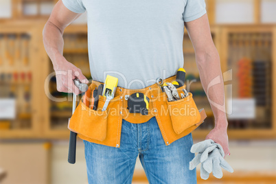 Composite image of technician holding gloves and hammer