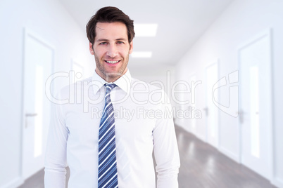 Composite image of smiling businessman standing with hands in po