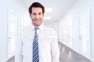 Composite image of smiling businessman standing with hands in po