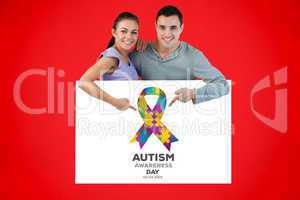 Composite image of young couple pointing at advertisement below