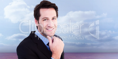 Composite image of businessman touching his chin while smiling a