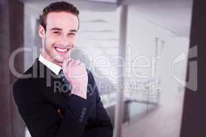 Composite image of happy businessman standing with hand on chin