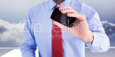 Composite image of hand of businessman showing smartphone