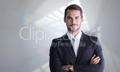 Composite image of smiling businessman posing with arms crossed