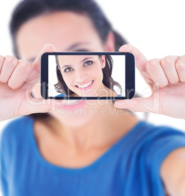 Composite image of pretty brunette taking a selfie