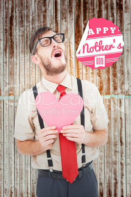 Composite image of geeky hipster crying and holding heart card