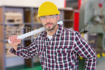 Composite image of handyman holding rolled up blueprint