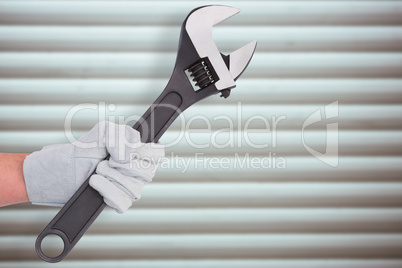 Composite image of mechanic holding spanners on white background