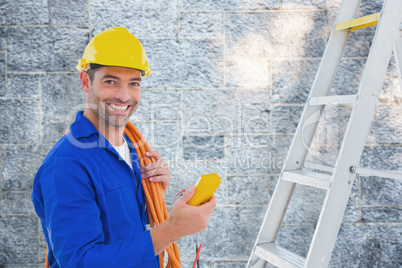 Composite image of smiling male electrician holding multimeter i