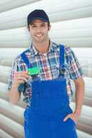 Composite image of confident plumber showing green card