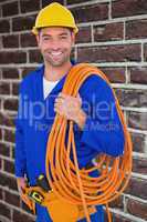 Composite image of smiling handyman with rolled wire on white ba