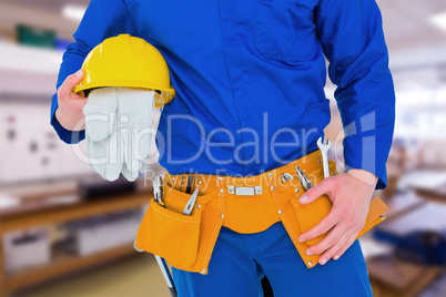 Composite image of handyman holding helmet