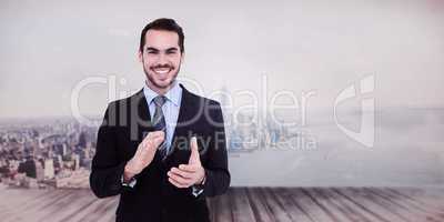 Composite image of happy businessman standing and applauding