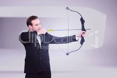 Composite image of businessman shooting a bow and arrow