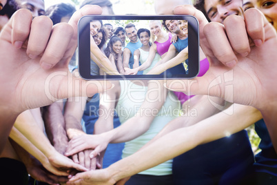 Composite image of hand holding smartphone showing