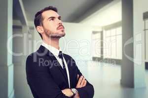 Composite image of thinking businessman with his arms crossed