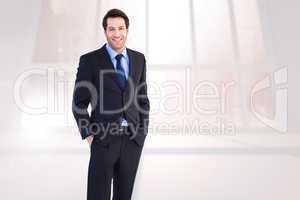 Composite image of smiling young businessman with hands in pocke