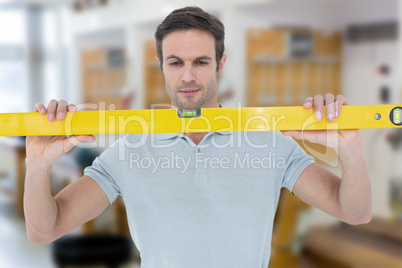 Composite image of repairman holding spirit level