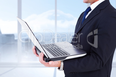 Composite image of businessman with watch using tablet pc