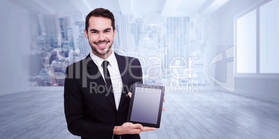 Composite image of smiling businessman showing his tablet pc