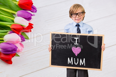 Composite image of cute pupil holding chalkboard