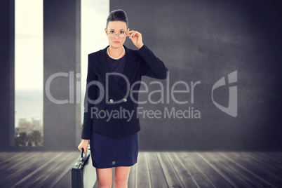 Composite image of elegant businesswoman in suit carrying briefc