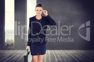 Composite image of elegant businesswoman in suit carrying briefc