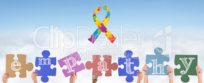 Composite image of hands holding up empathy jigsaw pieces