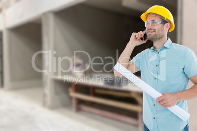 Composite image of male architect with blueprint talking on mobi