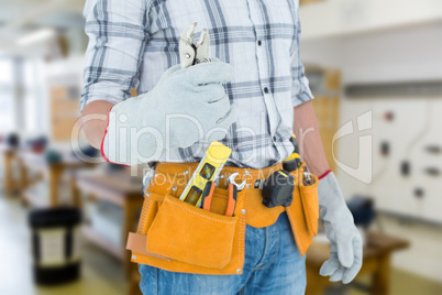 Composite image of technician with tool belt around waist holdin