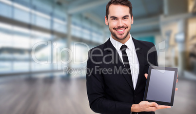 Composite image of smiling businessman showing his tablet pc