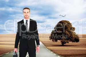 Composite image of serious businessman standing and holding brie