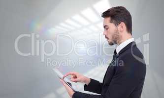 Composite image of concentrated businessman touching his tablet