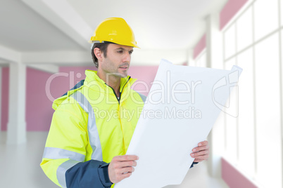 Composite image of architect analyzing blueprint over white back