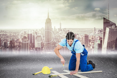 Composite image of repairman fixing screw on plank