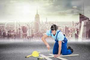 Composite image of repairman fixing screw on plank