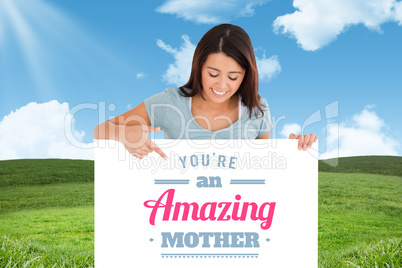 Composite image of portrait of a beautiful woman pointing at a b