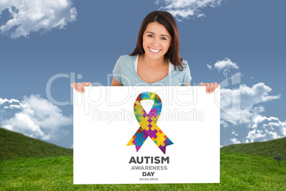 Composite image of beautiful woman holding a  board