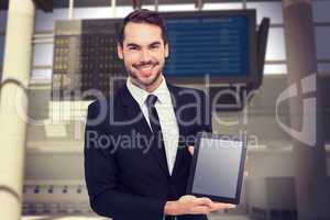 Composite image of smiling businessman showing his tablet pc