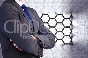 Composite image of man in a suit with folded arms