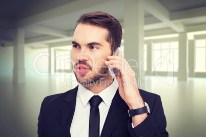 Composite image of smart businessman speaking on the phone