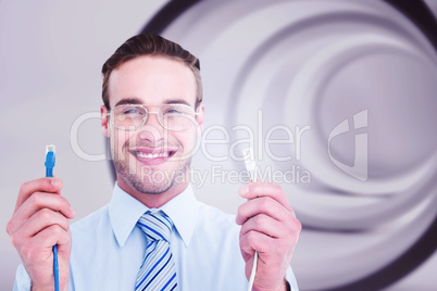 Composite image of geeky businessman holding two cables
