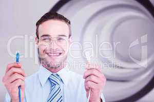 Composite image of geeky businessman holding two cables