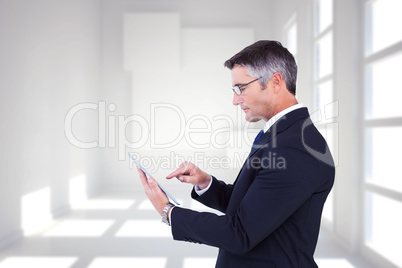 Composite image of mid section of a businessman touching tablet