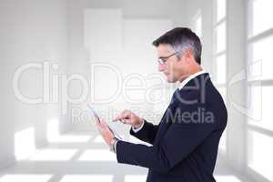 Composite image of mid section of a businessman touching tablet